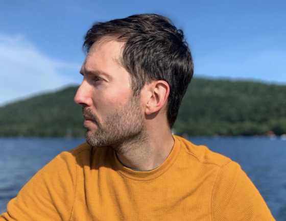 a man standing next to a body of water